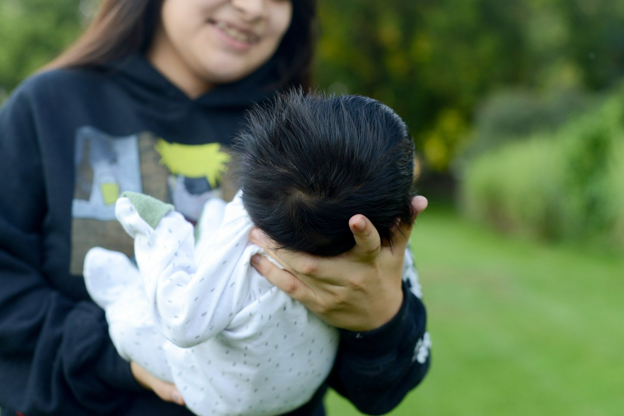 Teen mom holding her baby